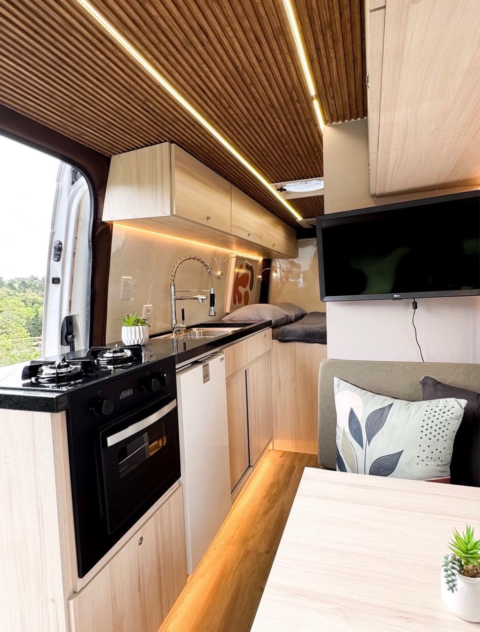 Interior de motorhome da Motorlife com cozinha, mesa e acabamento em madeira